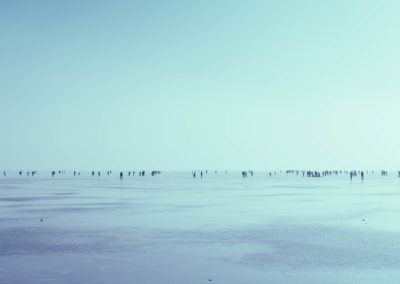 People walking on a mass body of a frozen water